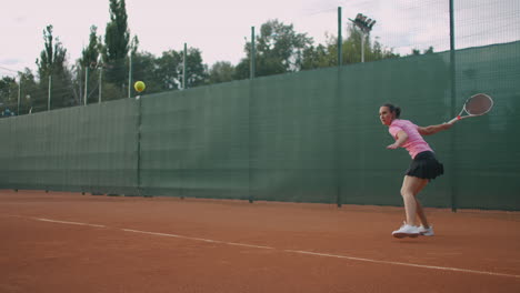 Junge-Tennisspielerin-Konzentriert-Sich-Auf-Ihr-Vorhandspiel.-Professionell-Ausgestattete-Frau,-Die-Mit-Einem-Tennisschläger-Hart-Auf-Den-Tennisball-Einschlägt.